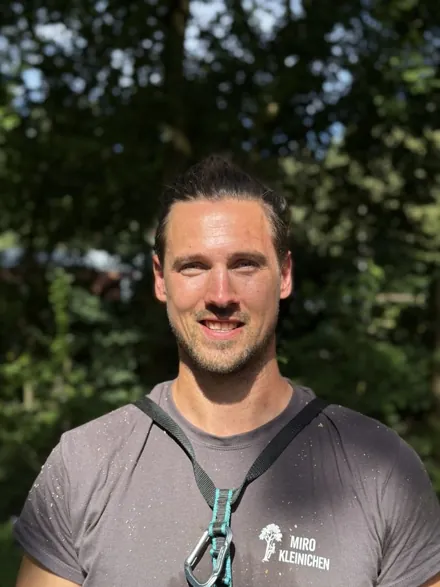 Miro Kleinichen im Firmenshirt vor Bäumen